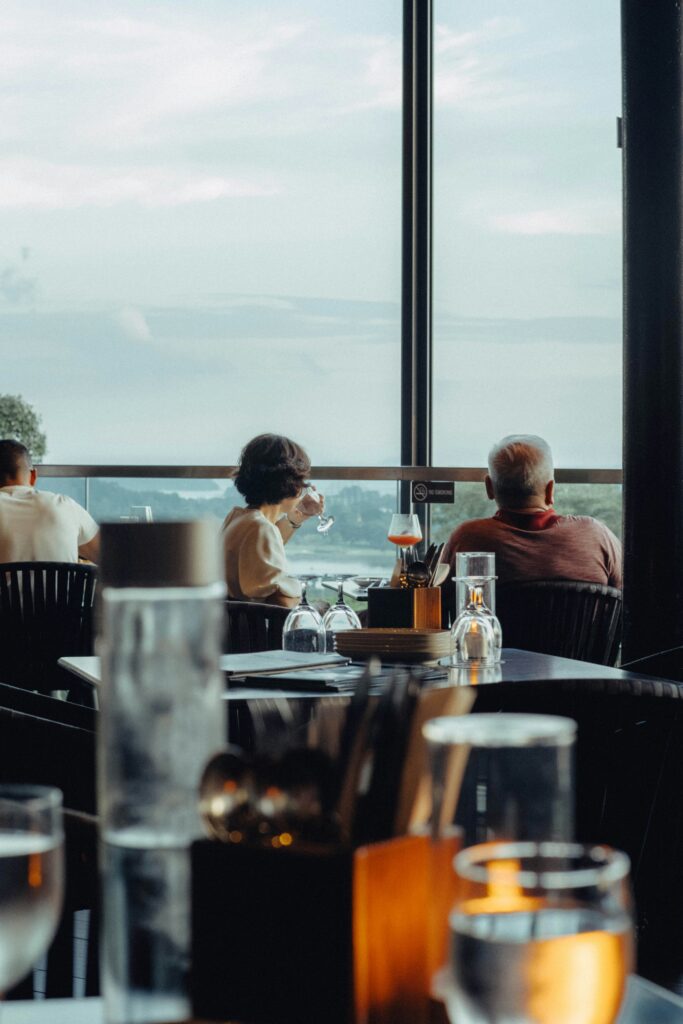 Older adults seated at a restaurant table by a window