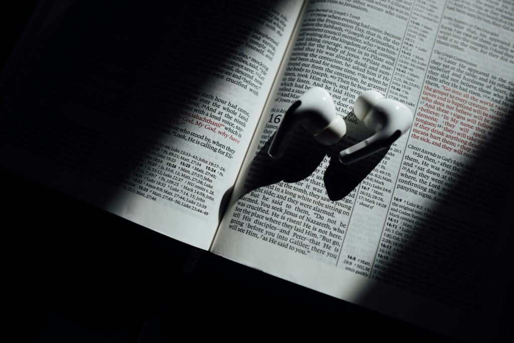 A pair of wireless earbuds resting on an open book