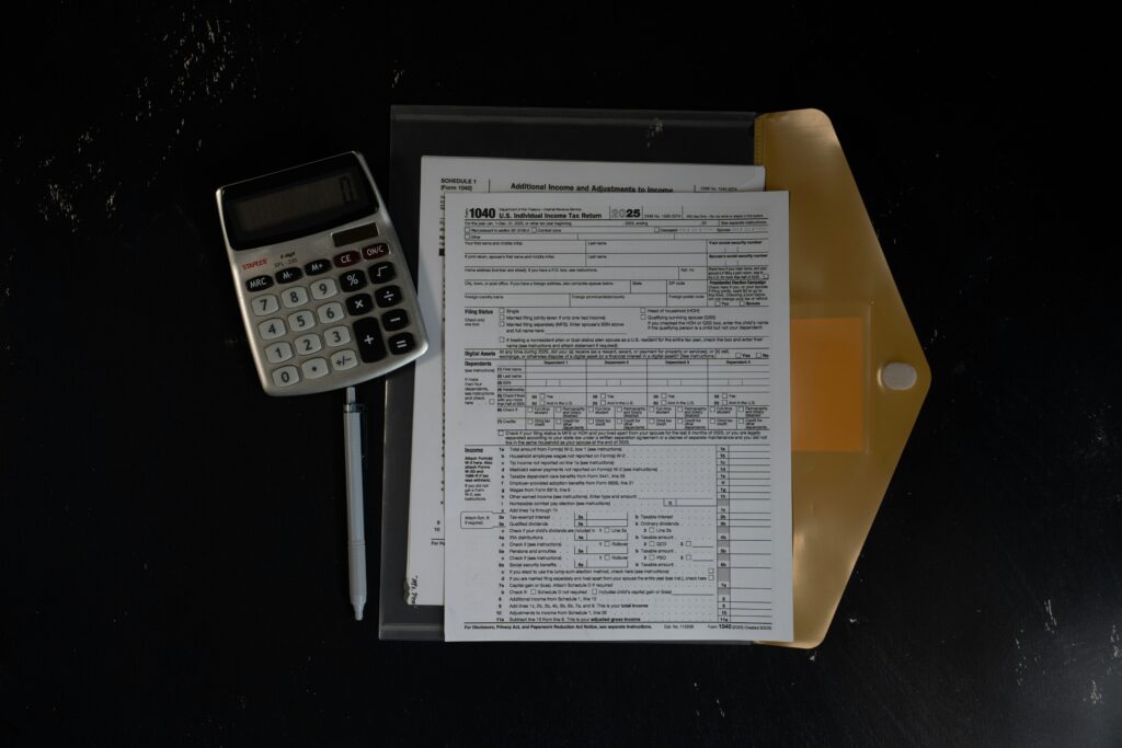A tax form and a calculator on a dark table