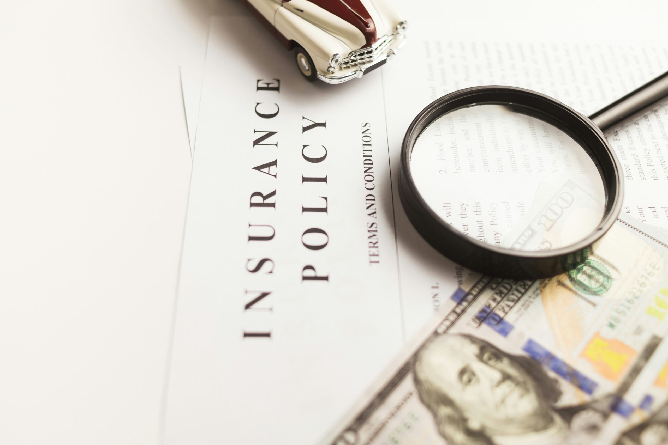 An insurance policy terms and conditions document under a magnifying glass